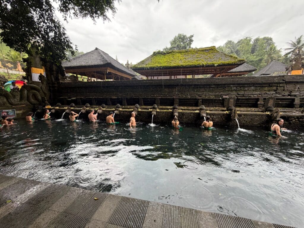Rituel de purification spirituelle dans le bassin en pierre d'un temple sacré à Bali