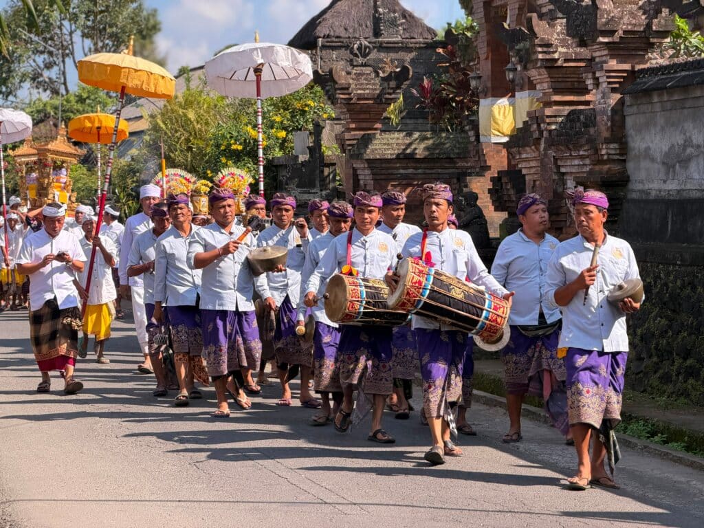Procession animée et danseuses traditionnelles en costumes de cérémonie lors d'une crémation (Ngaben) festive à Bali.