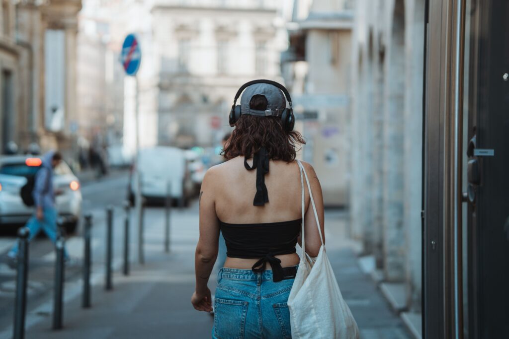 Ado portant des écouteurs dans la rue, symbolisant le fossé générationnel et la bulle musicale.
