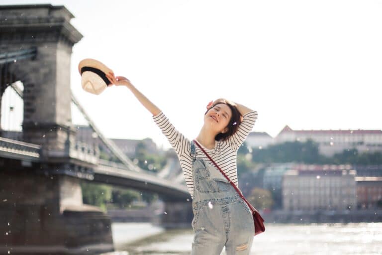Femme souriante profitant d'une escapade pour souffler et déculpabiliser de partir sans ses enfants.