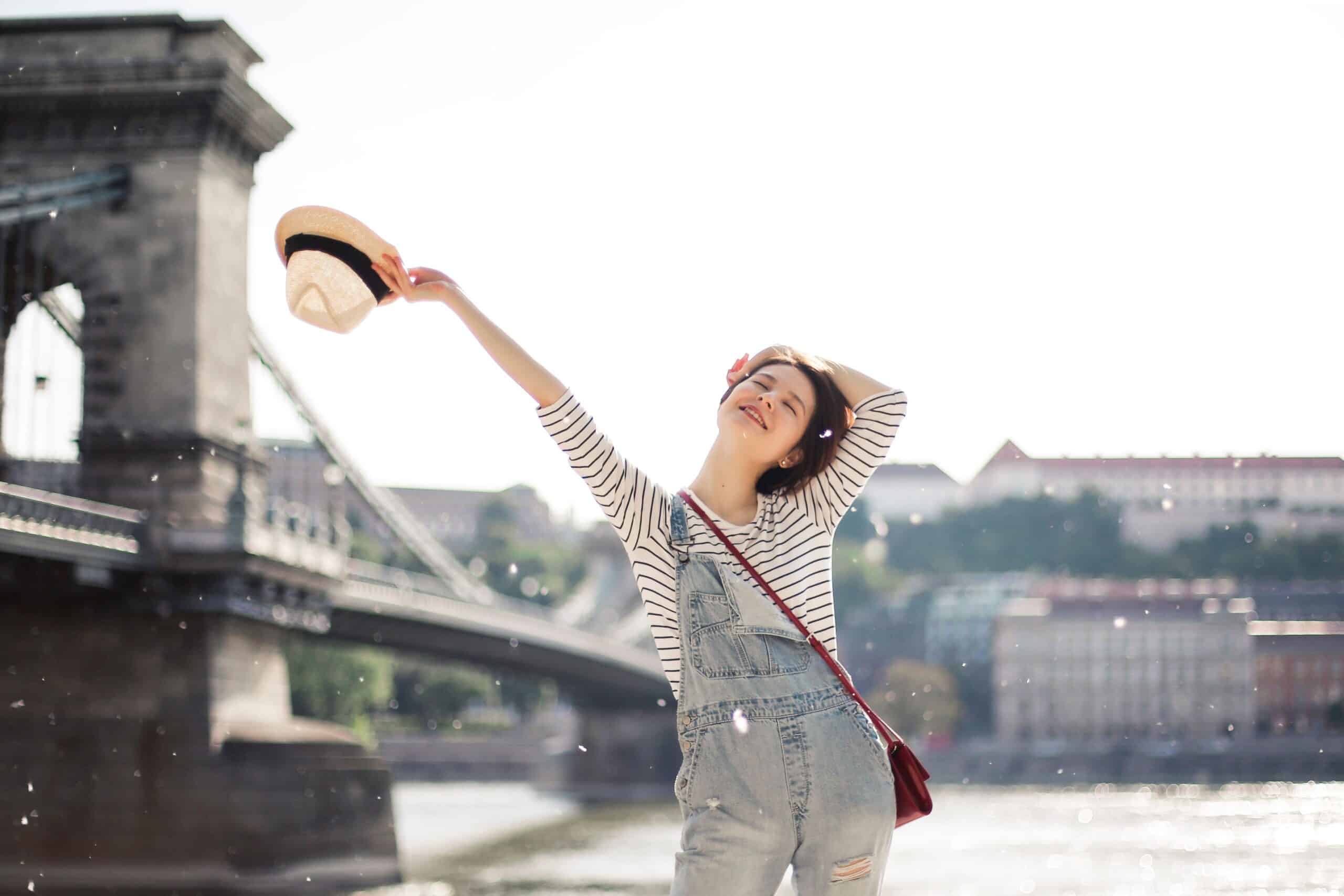 Femme souriante profitant d'une escapade pour souffler et déculpabiliser de partir sans ses enfants.