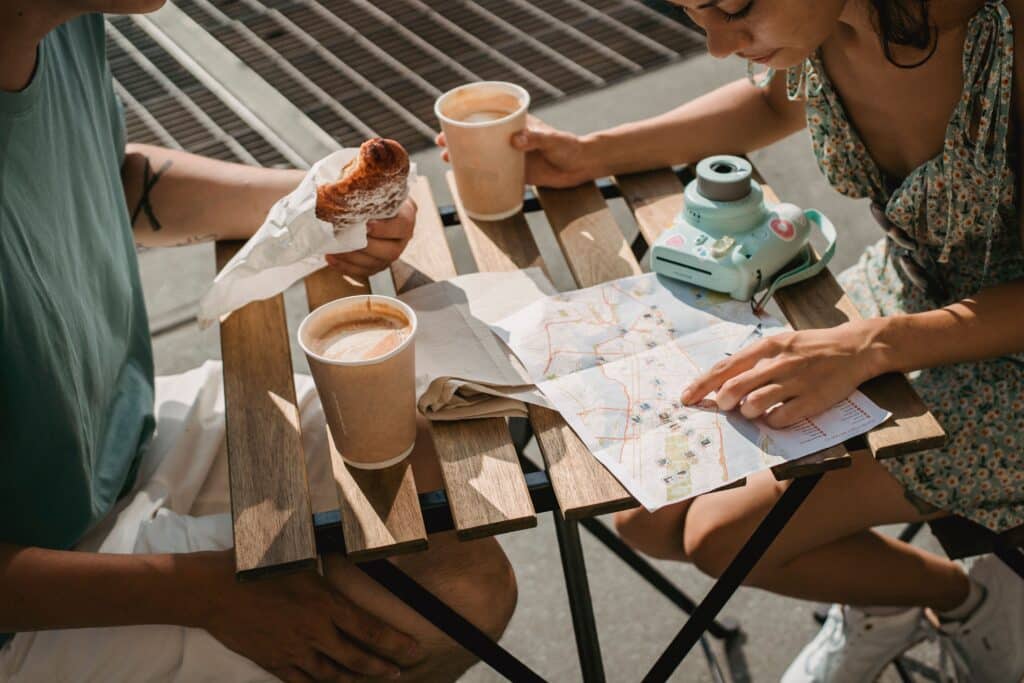 Duo planifiant un voyage sur-mesure détendu autour d'un café et d'une carte