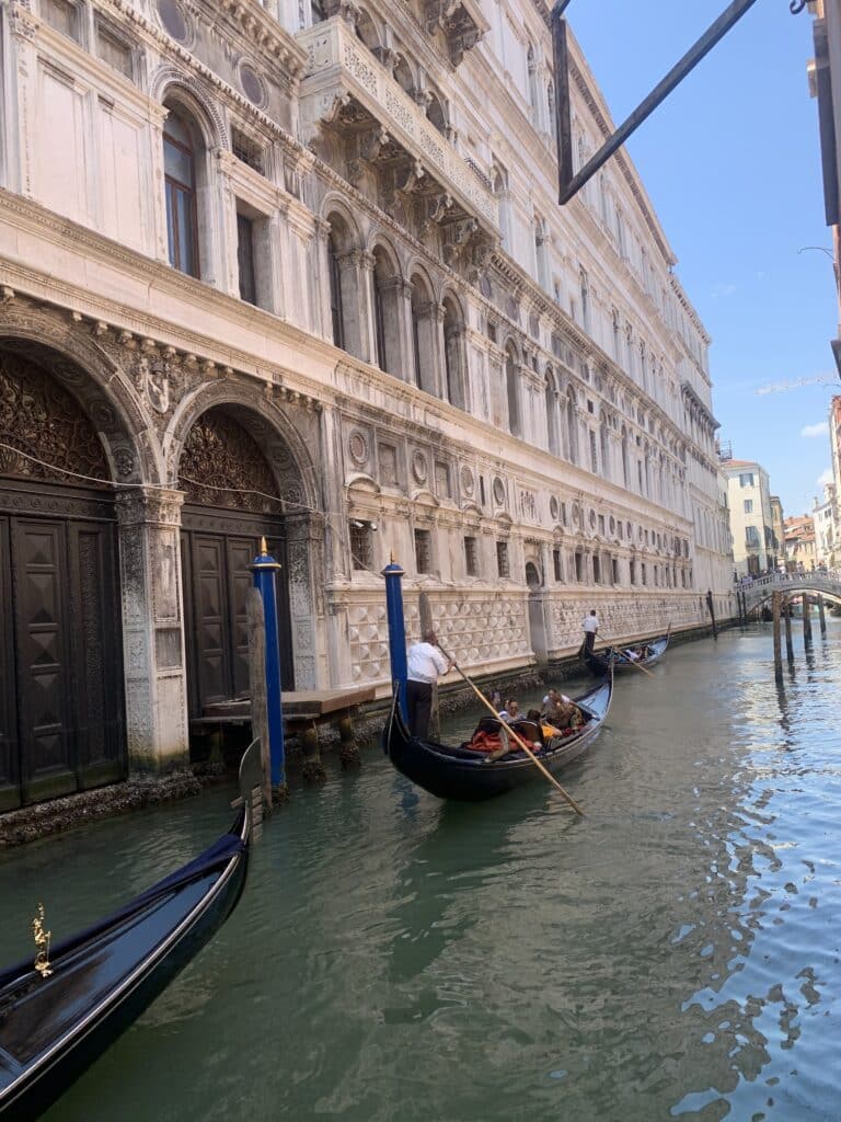 Détail d'une gondole élégamment amarrée devant l'architecture gothique du Palais des Doges à Venise, évoquant l'histoire et le romantisme de la Sérénissime.