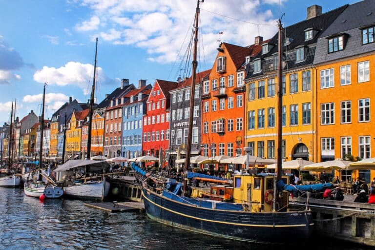 Façades colorées du quartier Nyhavn à Copenhague bordant le canal et ses bateaux amarrés.