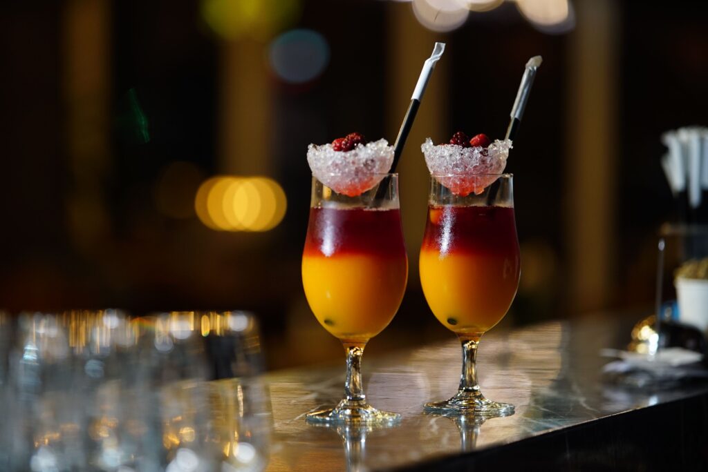 Cocktails élégants servis dans un bar tamisé, évoquant l'art du hygge et la douceur de vivre