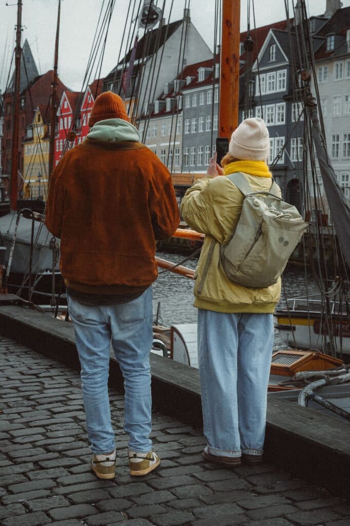 Couple de voyageurs partageant un moment complice en extérieur, l'essence même du hygge et du bonheur danois à deux