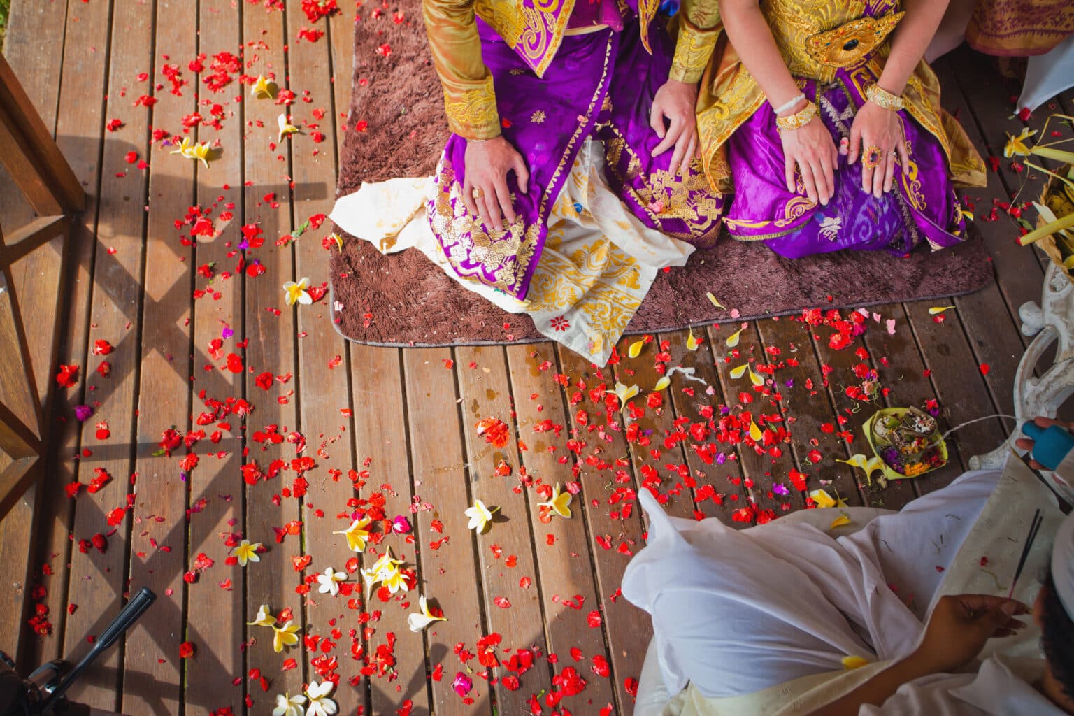 Cérémonie de mariage traditionnelle balinaise intime et spirituelle, parsemée de pétales de fleurs, pour célébrer votre mariage à la balinaise avec Heaven Collection.