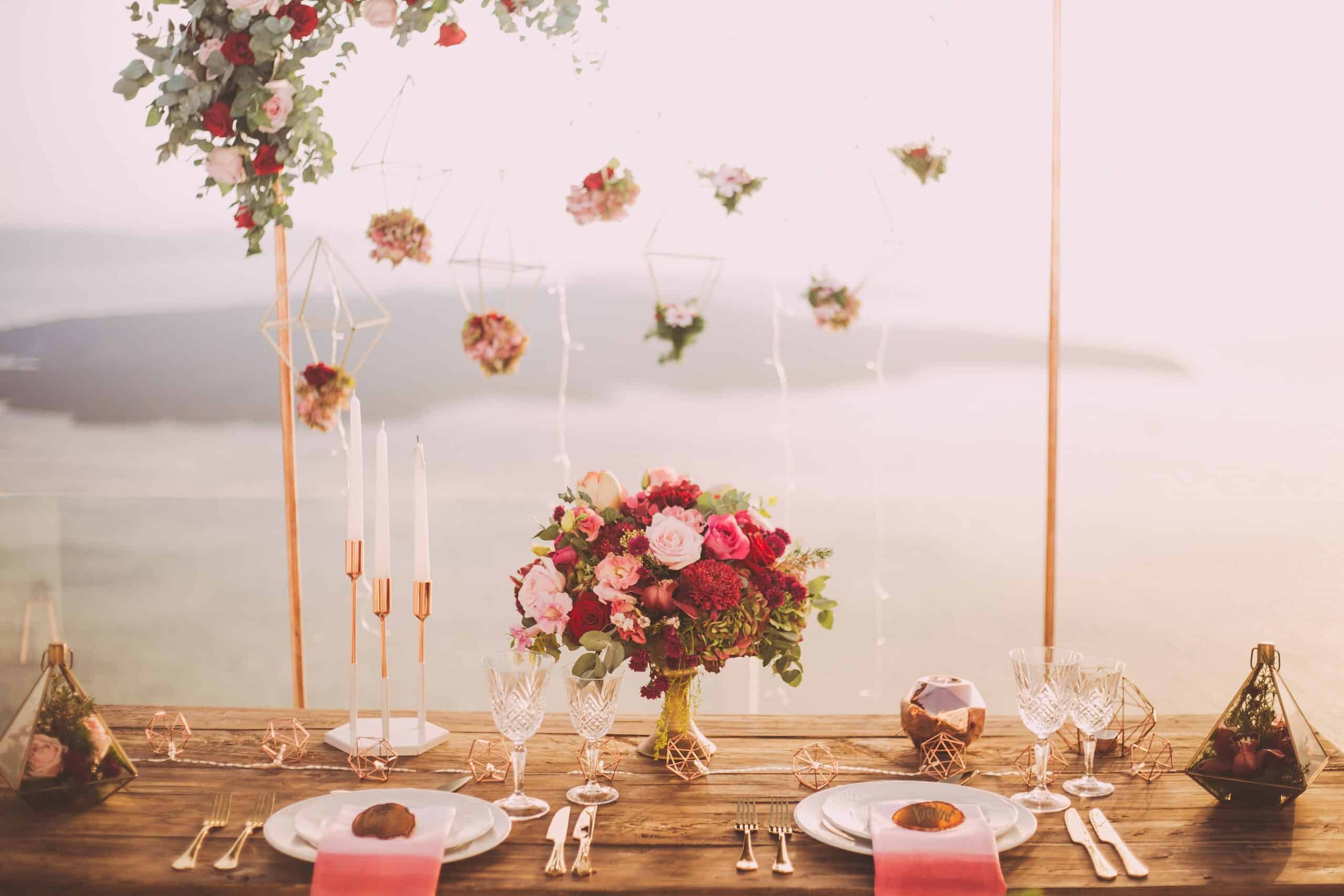 Décoration de table de mariage romantique en bord de mer, avec composition florale élégante et vaisselle raffinée pour une célébration intime.