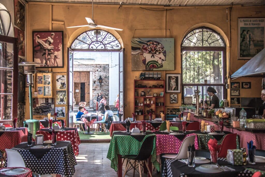 Ambiance chaleureuse et tables aux nappes colorées dans une trattoria italienne traditionnelle, voyage gourmand en duo Heaven Collection.