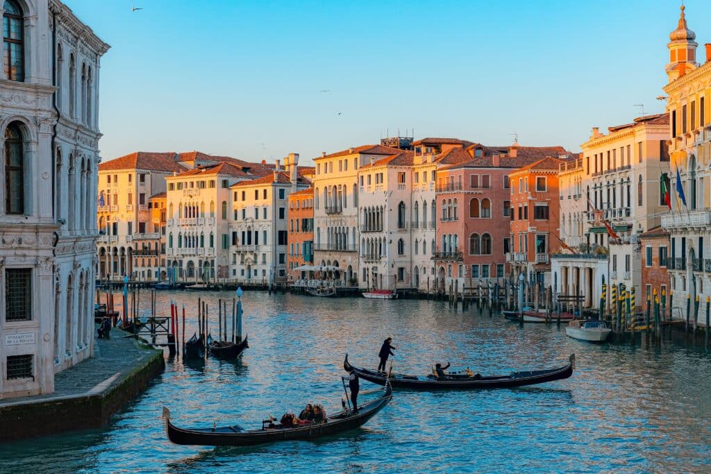 Vue féerique du Grand Canal à Venise baigné par la lumière dorée, avec des gondoles naviguant paisiblement. L'incarnation du romantisme vénitien.