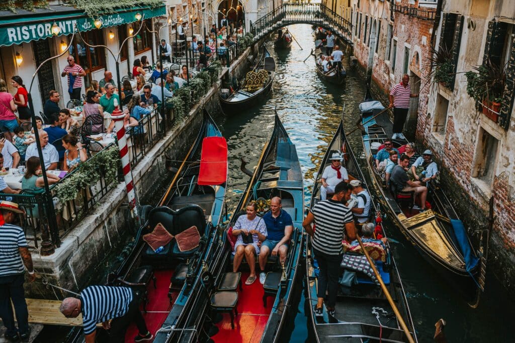Illustration du tourisme de masse à Venise, montrant la saturation des gondoles sur un canal étroit loin du romantisme attendu