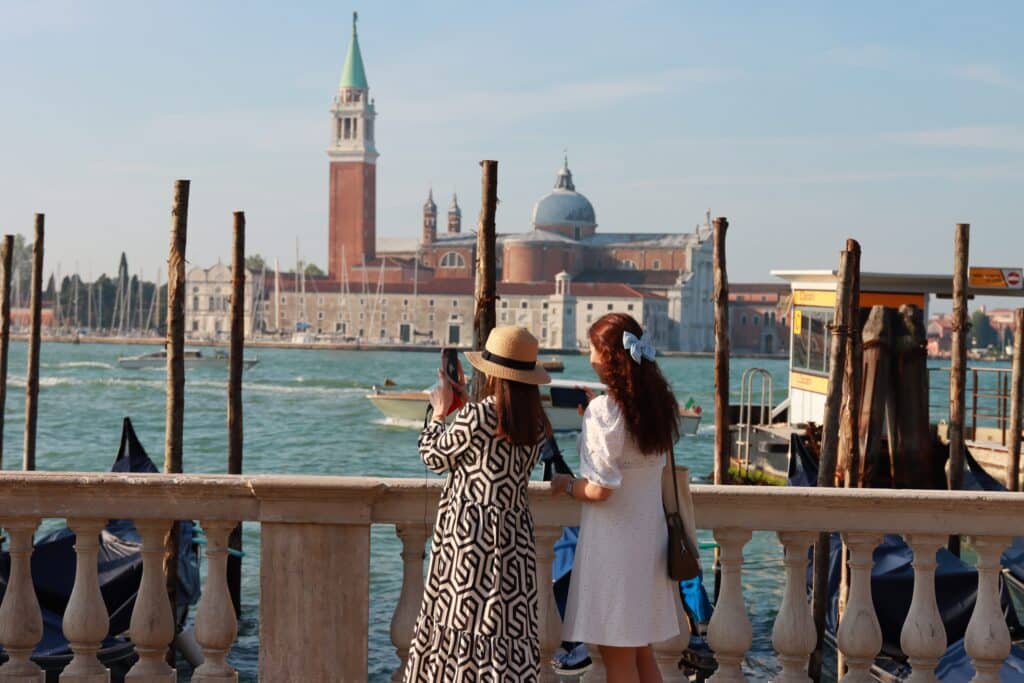 Deux personnes admirant la lagune et les gondoles à Venise.