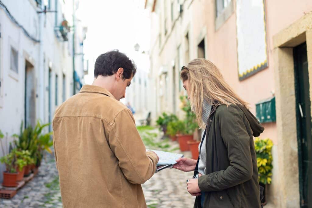 Duo de voyageurs lors d'une Parenthèse Impulsion, consultant une carte dans une rue en voyage
